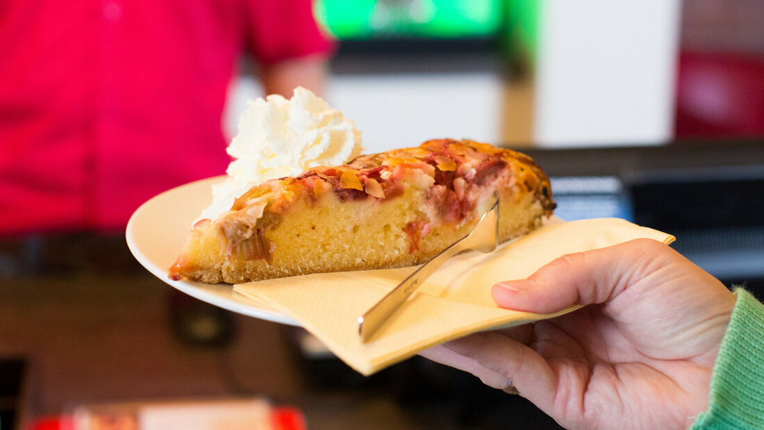 Stück Kuchen auf einem Teller wird gehalten.